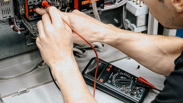Installateur controleert een elektrische installatie met een multimeter