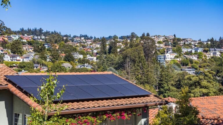 Woning met zonnepanelen en omliggende huizen in een woonwijk